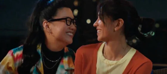 Queer character Alice portrayed by Sherry Cola laughing with a girl.